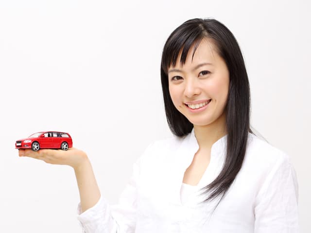 手に車のおもちゃを持った女性